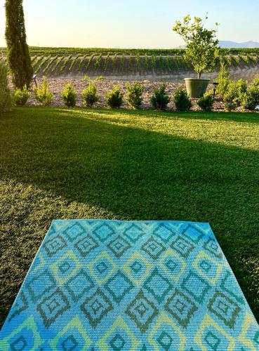 a blue and yellow rug on the grass in a yard at Domaine Chardonnay in Temecula