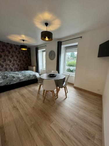 a bedroom with a bed and a table and chairs at Studio 2ème étage - Centre-ville - Local vélos disponible in Mayenne
