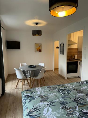 Il comprend une chambre avec une table et des chaises ainsi qu'une cuisine. dans l'établissement Studio 2ème étage - Centre-ville - Local vélos disponible, à Mayenne