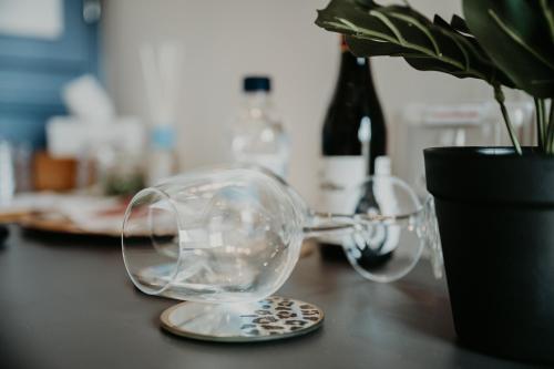 a pair of wine glasses on a table with a potted plant at Casa Rosanna Malta B&B Adults only 16 plus in Marsaskala
