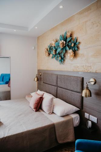 a bedroom with a large bed with flowers on the wall at Casa Rosanna Malta B&B Adults only 16 plus in Marsaskala