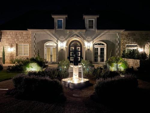 a house with lights on the front of it at night at Domaine Chardonnay in Temecula