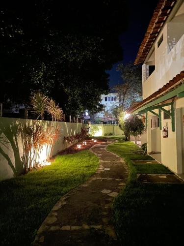 a pathway leading to a house at night at Pousada Maracaju in Porto De Galinhas