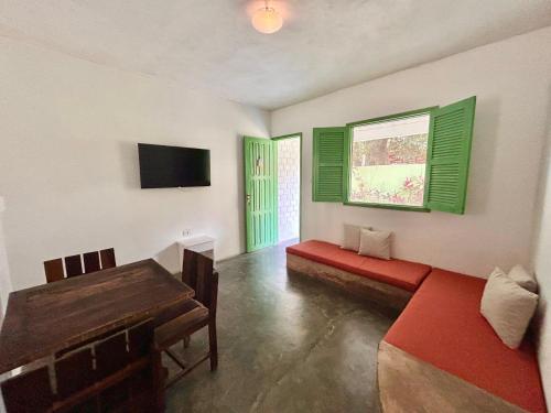 a living room with a red bench and a window at Pousada Maracaju in Porto De Galinhas