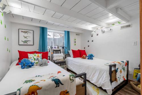 two beds in a room with red and white at Triceratops Landing I Fire Place I Games I Netflix in Drumheller