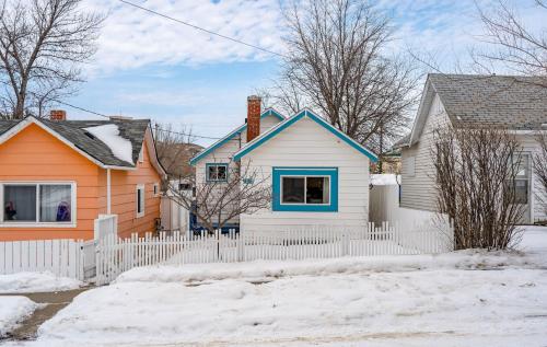 a house with a white fence in the snow at Triceratops Landing I Fire Place I Games I Netflix in Drumheller
