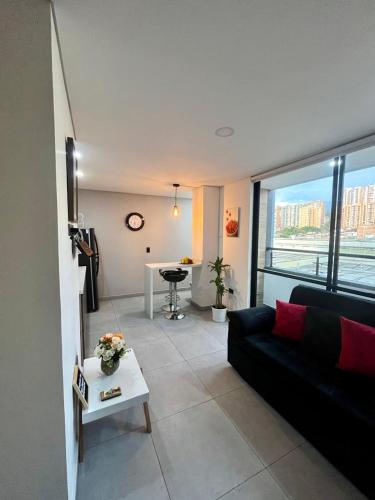 a living room with a black couch and a table at Apartamento exclusivo en Sabaneta, Antioquia in Sabaneta