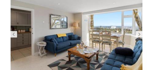 a living room with two blue couches and a table at 1 Dolphin Court, Brixham in Brixham