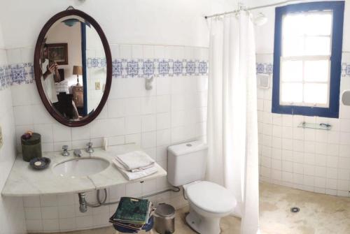 a bathroom with a toilet and a sink and a mirror at Casa colonial em Itù - Sorocaba in Mairinque