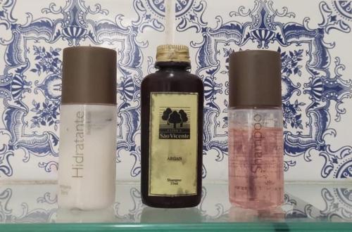 three bottles of cosmetics sitting on a shelf at Casa colonial em Itù - Sorocaba in Mairinque