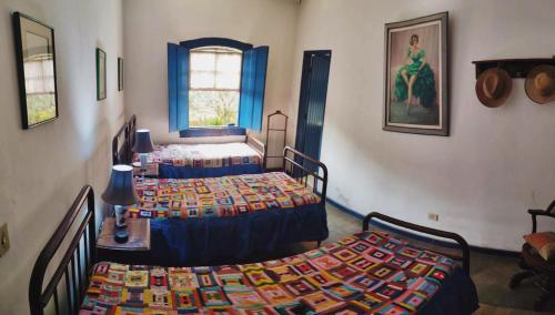 a room with two beds and a room with two windows at Casa colonial em Itù - Sorocaba in Mairinque