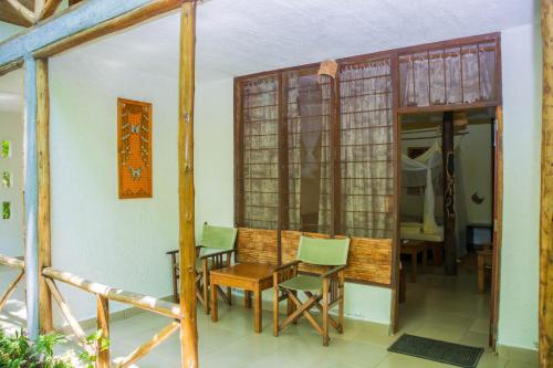 a dining room with a table and chairs in a room at Meru Mbega Lodge in Usa River