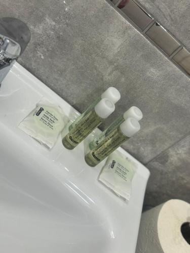 two bottles ofodorizers sitting on top of a bathroom sink at Apartament Grabowa in Kłodzko