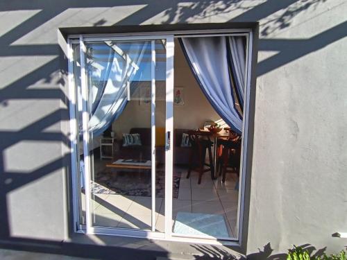 an open glass door with curtains in a room at Dalau on Main in Paarl