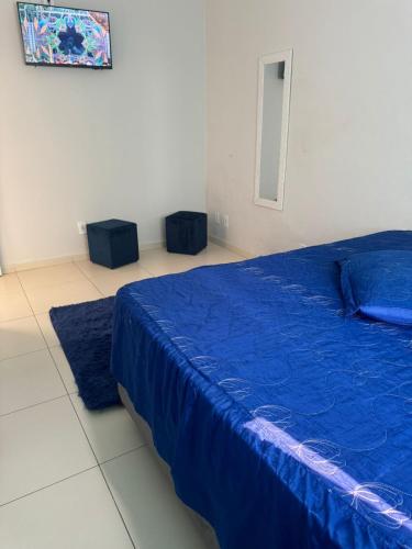 a bedroom with a blue bed and two stools at Hospedaria Mantovani in Tatuí