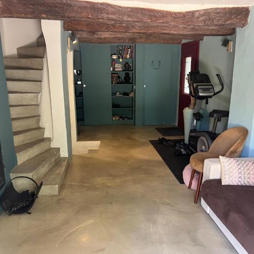 a living room with a staircase and a room with a treadmill at Bastide de Garidelle in Callas