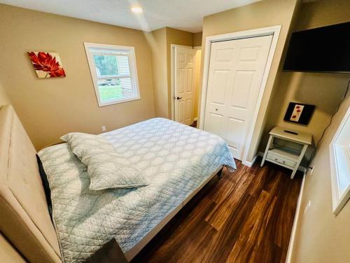 a small bedroom with a bed and a television at School Section Cottage Lake Access in Mecosta