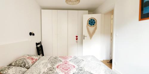 ein Schlafzimmer mit einem Bett und einer weißen Wand in der Unterkunft Boulogne, Near Roland Garros in Boulogne-Billancourt