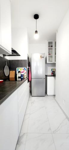  La cuisine est équipée de placards blancs et d'un réfrigérateur. dans l'établissement Boulogne, Near Roland Garros, à Boulogne-Billancourt