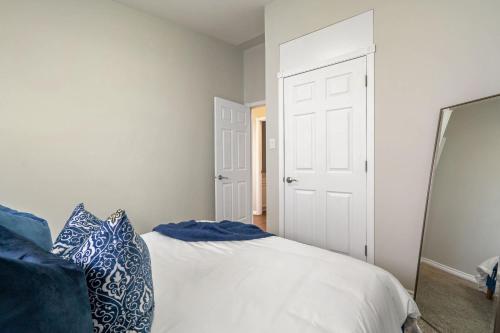 a bedroom with a bed with blue and white pillows at Timber Valley I HotTub I PingPong I Sleep 14 I BBQ in Drumheller