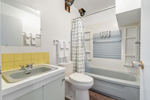 a white bathroom with a sink and a toilet at Timber Valley I HotTub I PingPong I Sleep 14 I BBQ in Drumheller