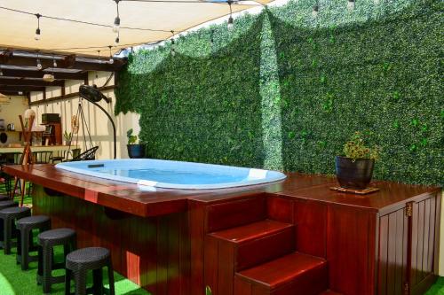 a green wall with a jacuzzi in a backyard at Casa Ana, Flores Island in Flores