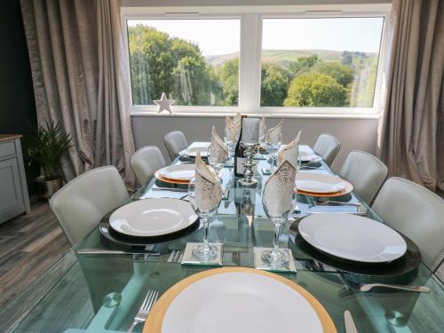 a dining room table with white chairs and a large window at The Old Telephone Exchange in Huddersfield