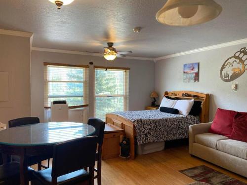 a bedroom with a bed and a table and a couch at President Studio Pool-Spa Ski-in out Gym, Sauna, Laundry, BBQ in Brian Head