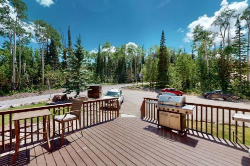 a deck with a grill and a car on a road at President Studio Pool-Spa Ski-in out Gym, Sauna, Laundry, BBQ in Brian Head
