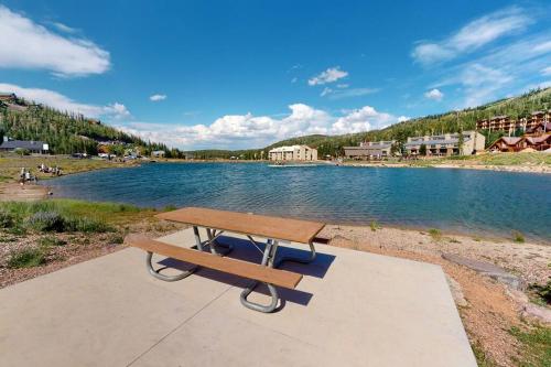 a picnic table sitting on a sidewalk next to a lake at President Studio Pool-Spa Ski-in out Gym, Sauna, Laundry, BBQ in Brian Head