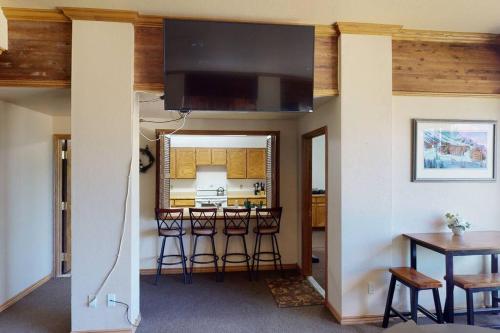 a living room with a table and a kitchen at President Studio Pool-Spa Ski-in out Gym, Sauna, Laundry, BBQ in Brian Head