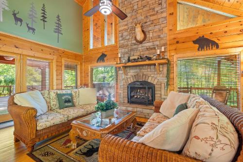 a living room with couches and a stone fireplace at Now and Forever cabin in Sevierville