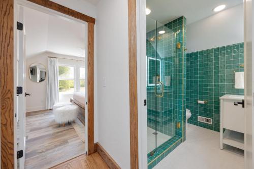 a bathroom with green tiled walls and a glass shower at 27 South - Large Lux Retreat With Hot Tub & Gameroom in Thompsons Station
