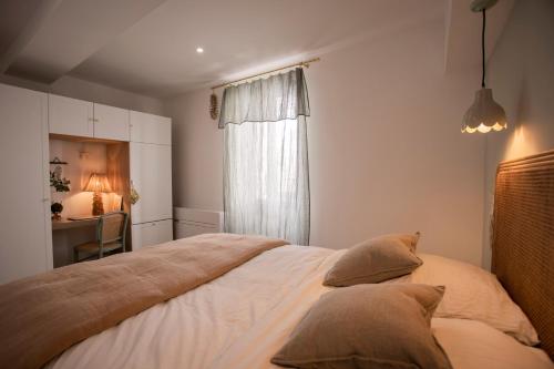 une chambre avec un lit avec des oreillers et une fenêtre dans l'établissement Mon cocon au cœur du village et des plages, à Bandol