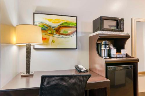 a room with a desk with a phone and a microwave at Best Western Plus Olathe Hotel in Olathe