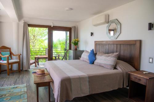 a bedroom with a large bed and a balcony at Casa Kalmar in Zipolite