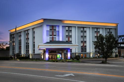 a large white building with purple lights in front of it at Holiday Inn Express & Suites Cincinnati Riverfront by IHG in Covington