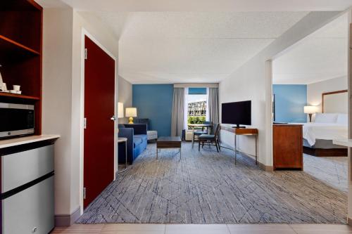a hotel room with a king bed and a living room at Holiday Inn Express & Suites Cincinnati Riverfront by IHG in Covington