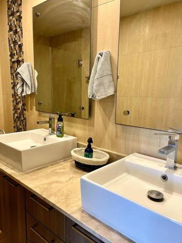 a bathroom with two white sinks and a mirror at Ocean 3 Condo By Abitre Playa Blanca in Río Hato