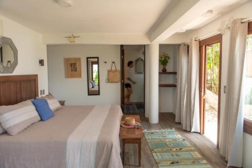a bedroom with a bed and a door to a bathroom at Casa Kalmar in Zipolite