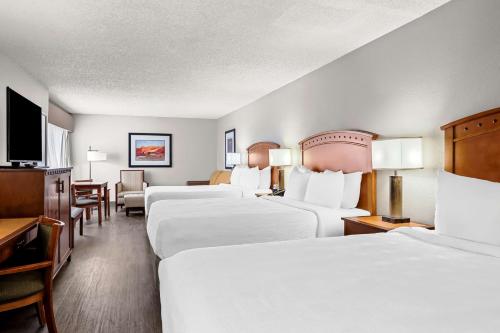 a hotel room with four beds and a flat screen tv at Best Western Plus At Lake Powell in Page