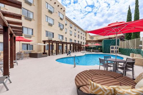 an outdoor patio with a pool and tables and umbrellas at Best Western Plus At Lake Powell in Page