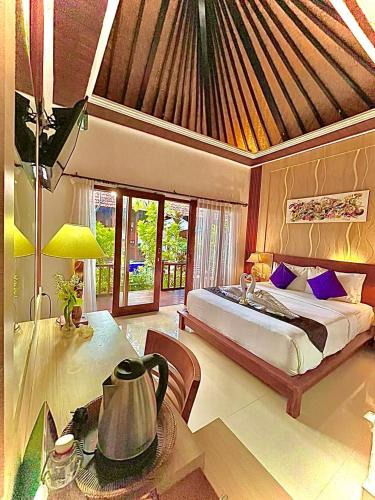 a bedroom with a bed and a table in a room at Wait Garden Cottage in Nusa Penida