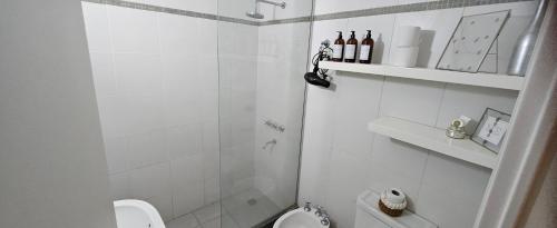 a white bathroom with a shower and a toilet at Mausann Pilar in Pilar