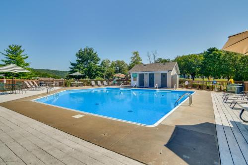 a large swimming pool with chairs and a house at 1 Mi to Silver Dollar City! Lake-View Family Haven in Branson