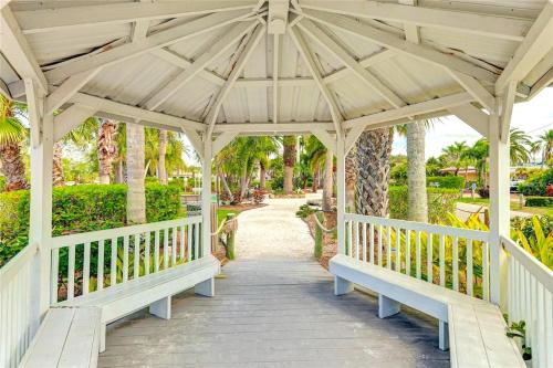 a wooden gazebo with benches on a walkway at New Listing! Pool Jacuzzi, 3-min to Beach Bars & Entertainment! in Siesta Key
