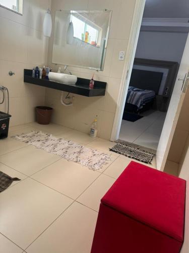 a bathroom with a sink and a red rug at Hospedaria Mantovani in Tatuí