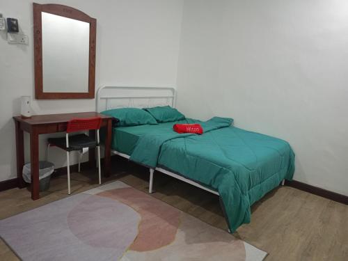 a bedroom with a bed and a desk and a mirror at Umieta Homestay in Johor Bahru