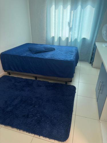 two beds in a room with two blue rugs at Hospedaria Mantovani in Tatuí