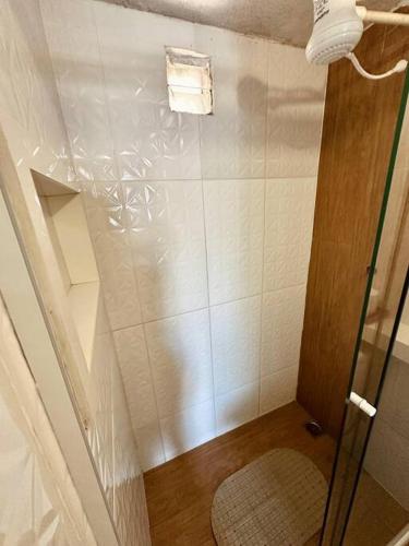 a bathroom with a shower with a tiled wall at Studio completo com ar condicionado, na Verolme in Angra dos Reis
